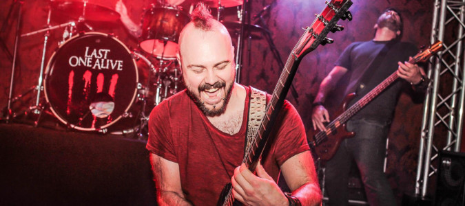 Vibing With The Crowd, Kiss The Ground Video Launch last one alive ric kneeling and smiling while shredding